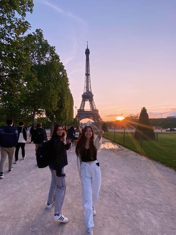 2 东航卡帕 students pose in front of Eiffel Tower at sunset