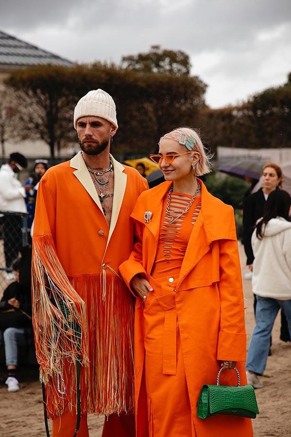 A couple wearing orange in Jardin des Tuileries at 巴黎 Fashion Week 2022