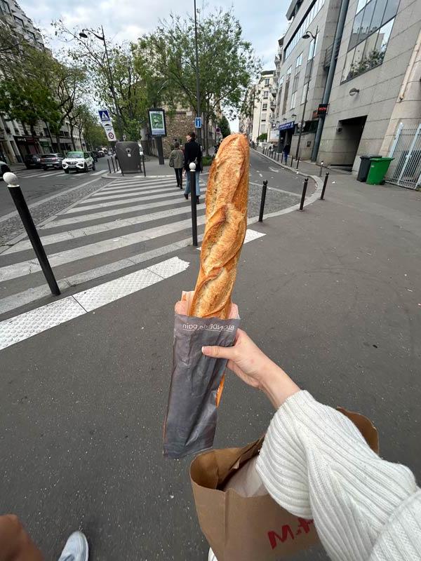 Student holding a fresh baguette in the streets of 巴黎